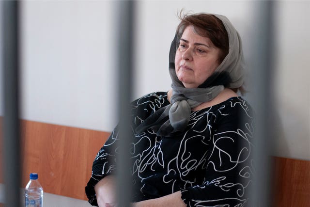 Zarema Musayev sits behind bars in a courtroom in Grozny, Russia