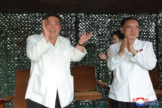 North Korean leader Kim Jong Un, left, claps while watching what North Korea says is the test-firing of an Hwasong-18 ICBM 