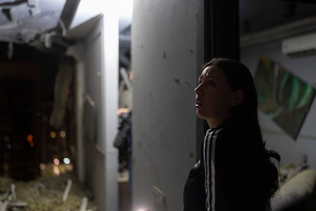 A resident surveys her neighbour’s apartment damaged in Russia’s air attack in Kyiv, Ukraine 