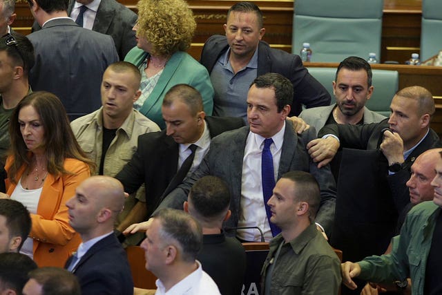 Bodyguards guard Kosovo Prime Minister Albin Kurti, centre, during a brawl in Kosovo’s parliament in Pristina 