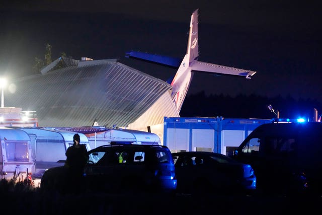 The tail of a Cessna 208 plane sticks out of a hangar after it crashed there in bad weather in Chrcynno, central Poland 