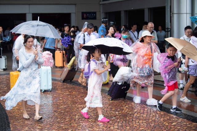 Tourists walk in the rain as Typhoon Talim approaches in Macao in southern China on Monday