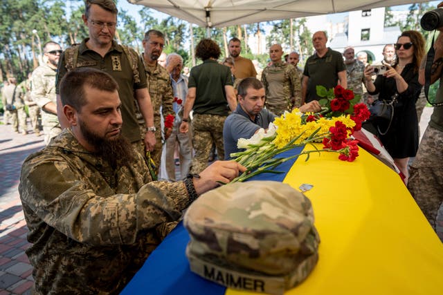 A Ukrainian serviceman pays his last respects to Nicholas Maimer, a US citizen and army veteran who was killed during fighting in Bakhmut against Russian forces 