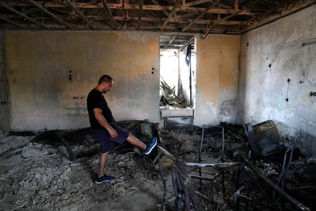 A man checks his burnt out house in Mandra