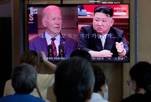 A TV screen shows US President Joe Biden, left, and North Korean leader Kim Jong Un during a news programme reporting on American soldier Travis King at Seoul Railway Station in South Korea