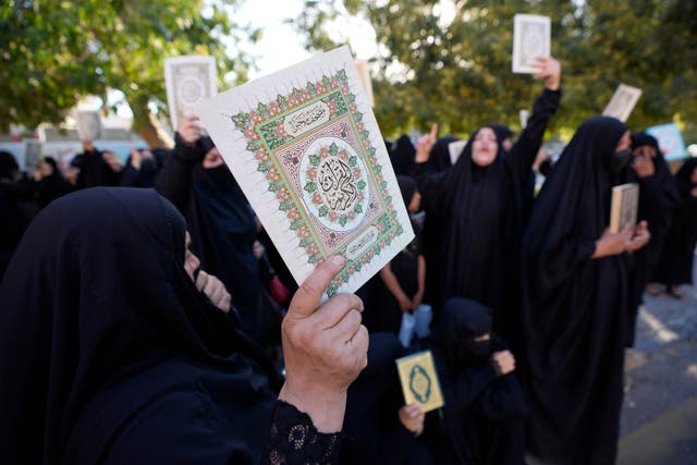 Iraqis raise copies of the Koran