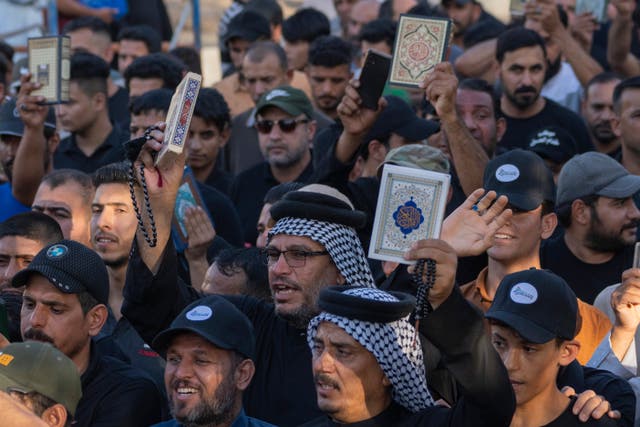 Protesters hold up the Koran