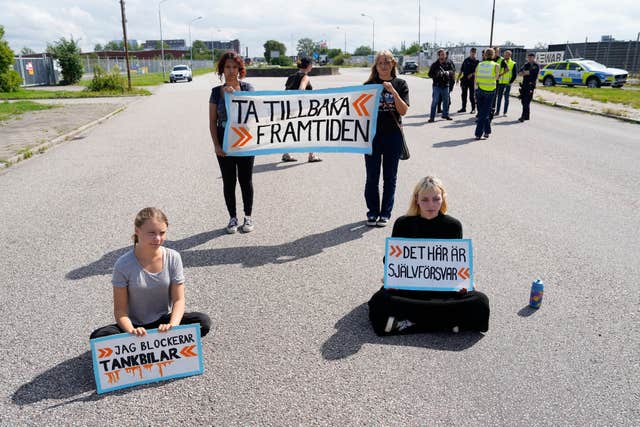 Greta Thunberg, left, and other activists block the entrance to an oil facility in Malmo, Sweden