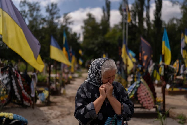 Svitlana Sushko, 62, sobs while visiting the grave of her youngest son, a Ukrainian soldier who was killed last year in the war against Russia, in Kyiv, Ukraine