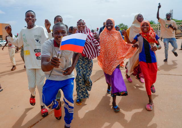 Supporters of Niger’s ruling junta hold a Russian flag in Niamey