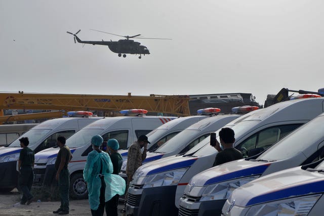 helicopter takes off and medical workers stand by ambulances