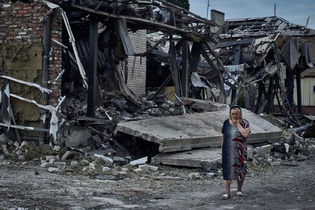 A woman reacts at the scene of a building damaged after recent Russian missile strikes 