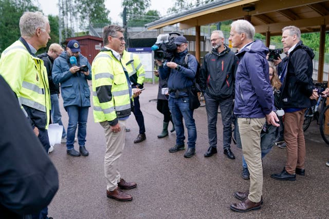 Norway’s Prime Minister and transport minister Jonas Gahr Store and Jon-Ivar Nygard talk to the media at the site damaged by flood