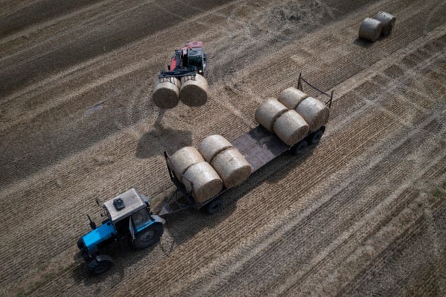 A tractor collects straw on a field in Zhurivka, Kyiv region, Ukraine