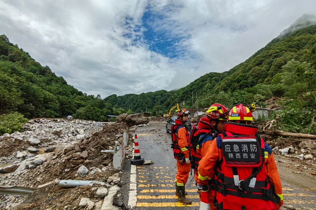 Rescue workers gather at the aftermath of a mudslide in Weiziping village of Luanzhen township