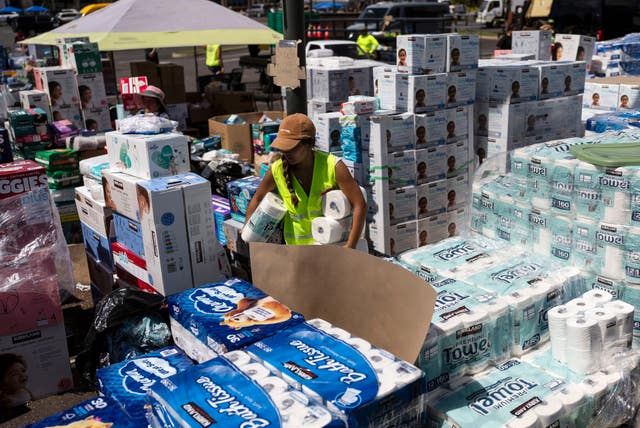 A volunteers works at a food and supply distribution centre