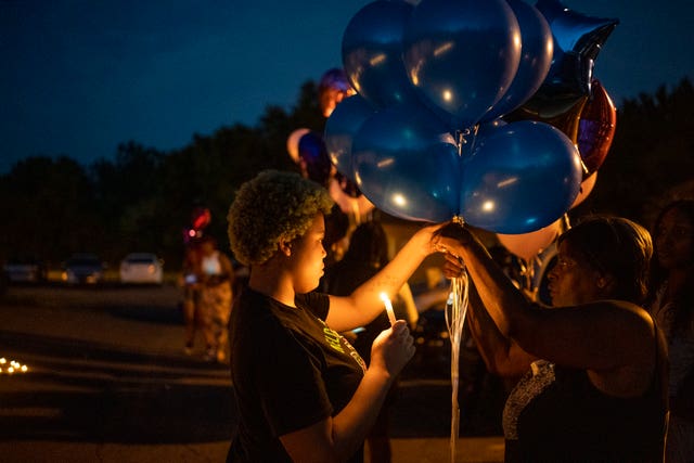 Nadine Young, right, the grandmother of Ta’Kiya Young, gathers with family and friends during a candlelight vigil