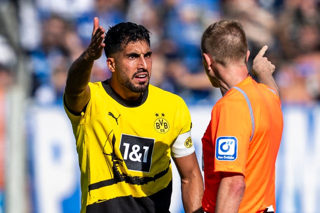 Borussia Dortmund’s Emre Can, left, complains to the referee