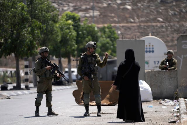 Soldiers with Palestinian woman