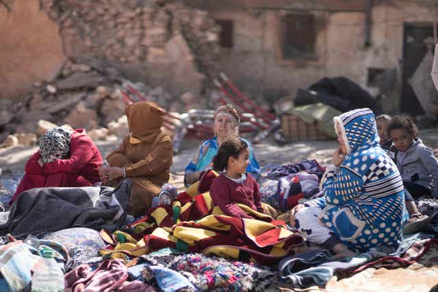 Families sit outside their destroyed homes following the earthquake 