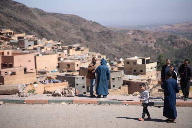 Villagers stand next to rubble after an earthquake in Moulay Brahim village, near Marrakech, Morocco