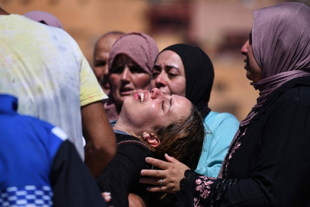 Women cry as they mourn victims of the earthquake 