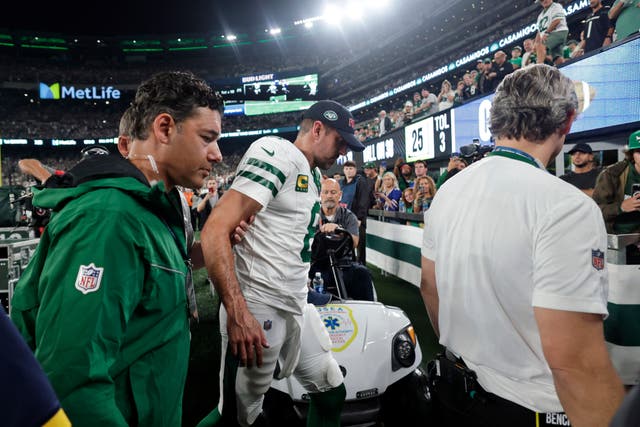 New York Jets quarterback Aaron Rodgers is helped off the field after getting injured during the first quarter of an NFL football game against the Buffalo Bills in East Rutherford, New Jersey