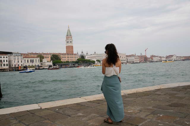 A tourist stands in front of St Mark’s Square in Venice, Italy