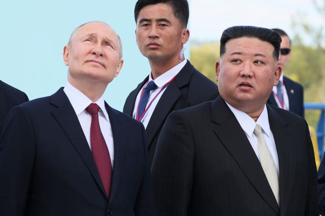 Mr Putin and Mr Kim look at something military and impressive