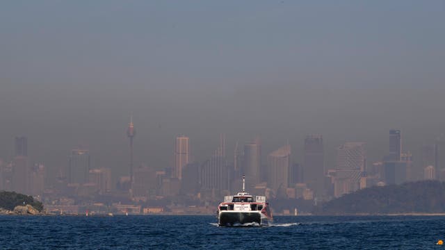 A ferry on the water as smoke covers Sydney