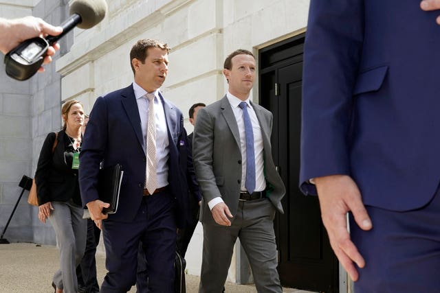 Meta chief executive Mark Zuckerberg, right, departs following a closed-door gathering of leading tech CEOs to discuss the priorities and risks surrounding artificial intelligence and how it should be regulated, past a crowd of media and a protester dressed as the Monopoly Man, on Capitol Hill in Washington