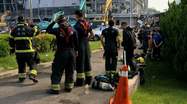 Firefighters take rest near the burned factory