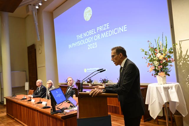 Thomas Perlmann, secretary of the Nobel Assembly, right, announces the winner of the 2023 Nobel Prize in Physiology or Medicine to Katalin Kariko and Drew Weissman
