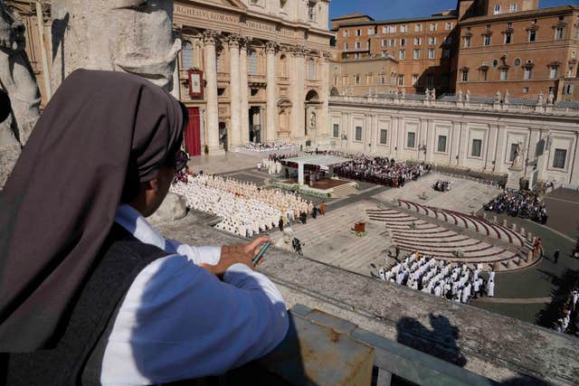 A nun watches for a terrace as Pope Francis presides over mass 