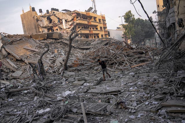 Palestinians inspect the rubble of a building after it was struck by an Israeli airstrike in Gaza City