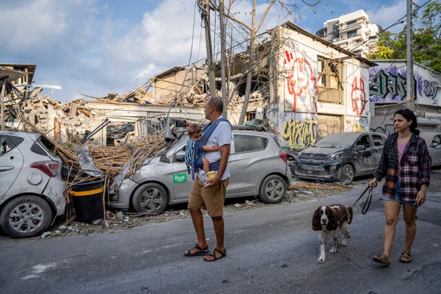 Israelis inspect the rubble of a building a day after it was hit by a rocket fired from the Gaza Strip