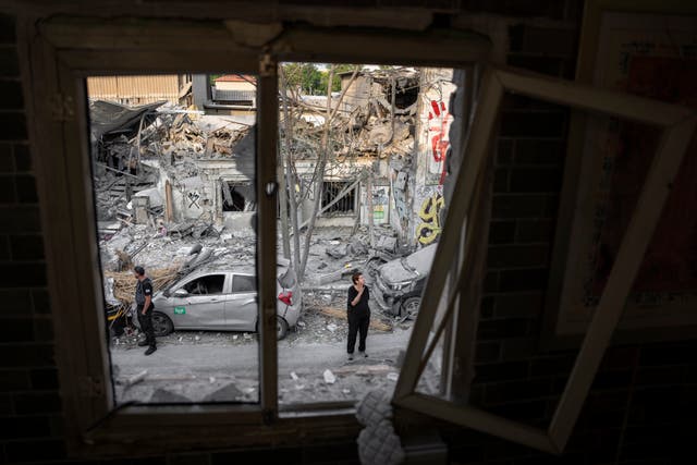 Israelis inspect the rubble of a building