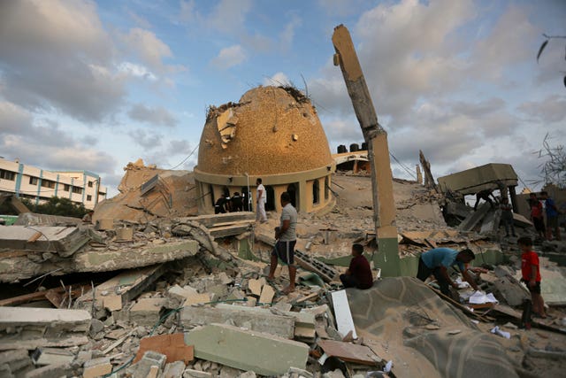 People stand outside a mosque destroyed in an Israeli air strike in Khan Younis, Gaza Strip