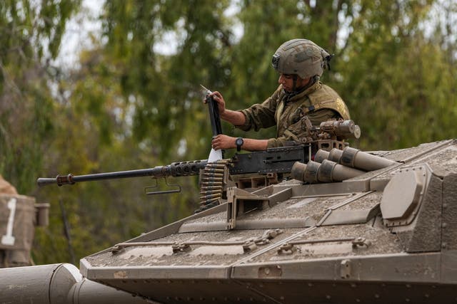 An Israeli soldier works on a tank at a staging ground near the Israeli Gaza border on Monday
