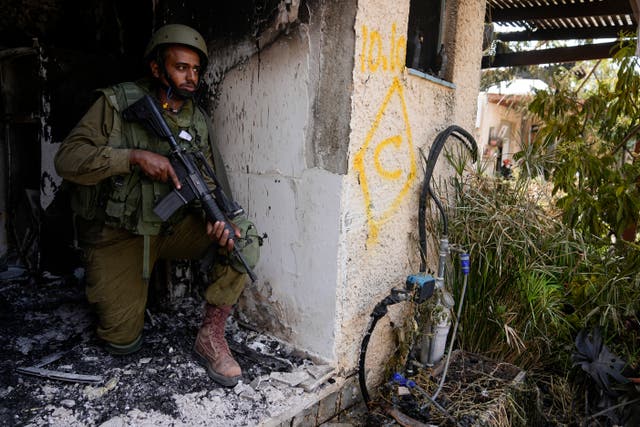 An Israeli soldier takes a position in Kfar Azza 