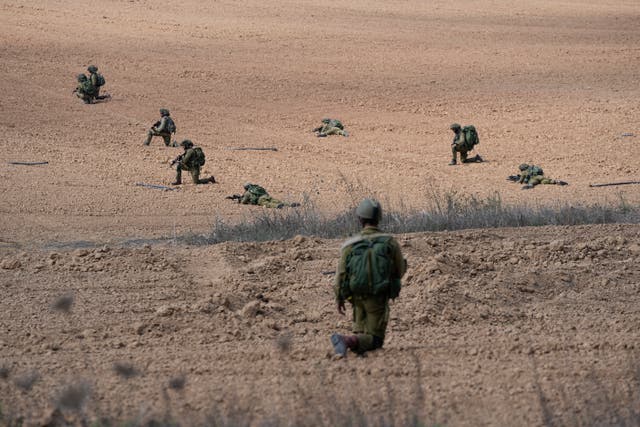 Israeli soldiers take positions near Kfar Azza 