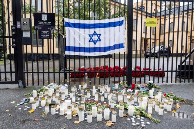 Flowers and candles are placed outside an Israeli embassy