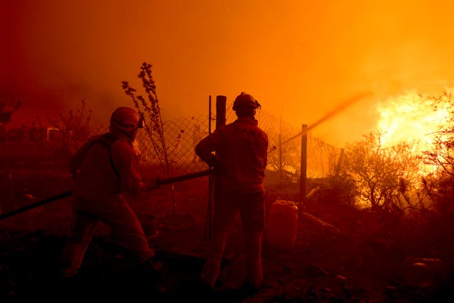 Firefighters work to put out a forest fire on the outskirts of Villa Carlos Paz in Cordoba province