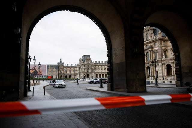 Police officers stand guard outside the Louvre