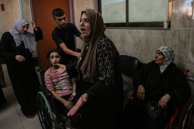 A Palestinian woman reacts next to the wounded at al-Aqsa hospital in Deir el-Balah in the Gaza Strip 
