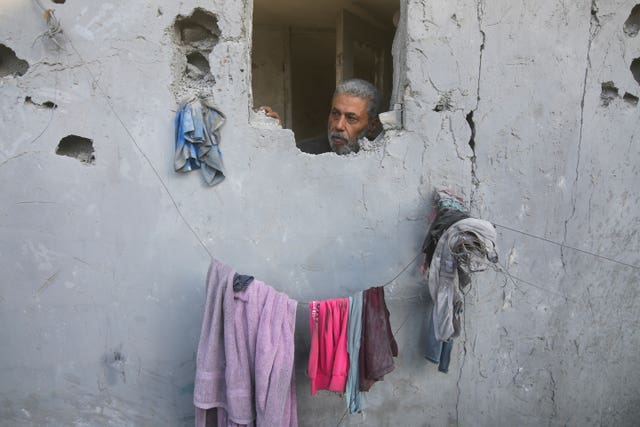 A Palestinian looks on from his house, damaged by Israeli airstrikes, in Rafah, southern Gaza Strip