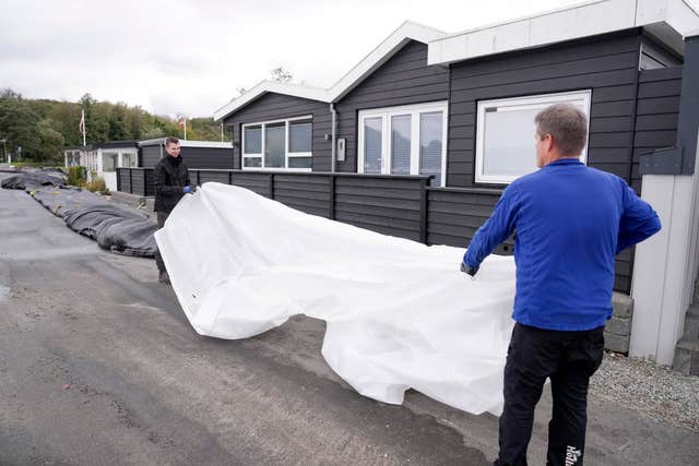 Jacob Nissen and Christian Mikkelsen, right, secure their summer house at Sonderballe Strand near Haderslev, southern Denmark 