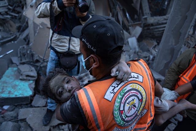 Palestinians evacuate wounded from a building destroyed in Israeli bombardment in Khan Younis, Gaza Strip