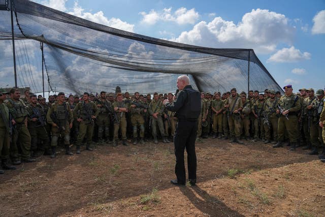 Israel’s defence minister Yoav Gallant, wearing a protective vest, speaks with Israeli soldiers in a staging area near the border with the Gaza Strip in southern Israel