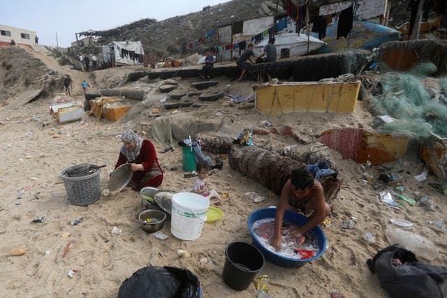 Palestinians use sea water to bathe and clean their tools and clothes, because of the continuing water shortage in the Gaza Strip, on the beach of Deir al-Balah